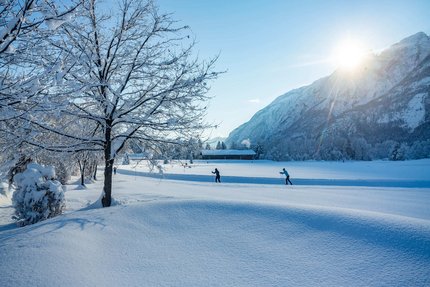 IBU Cup 2025 © Martin Lugger Winterlandschaft mit verschneiten Bäumen und Langläufern bei Sonnenschein