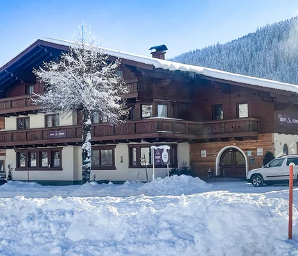 Auszeit Filzmoos © Auszeit Filzmoos - Kai-Uwe Wagner Snow-covered chalet with tree and parked cars in a winter mountain setting