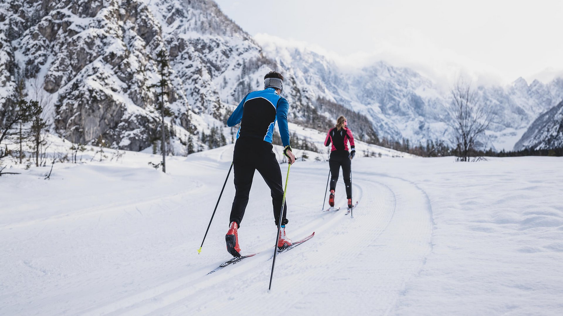 Langlauf Urlaub © Ciril Jazbec Zwei Langläufer auf verschneiter Loipe in bergiger Winterlandschaft