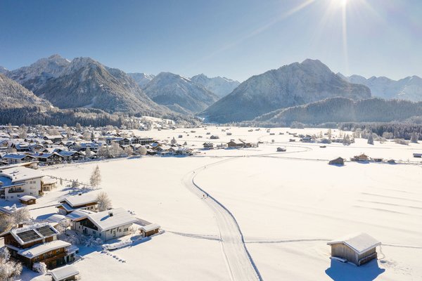Deutschland © Tourismus Oberstdorf - Eren Karaman Verschneites Dorf vor Bergen bei klarem Himmel und Sonnenschein