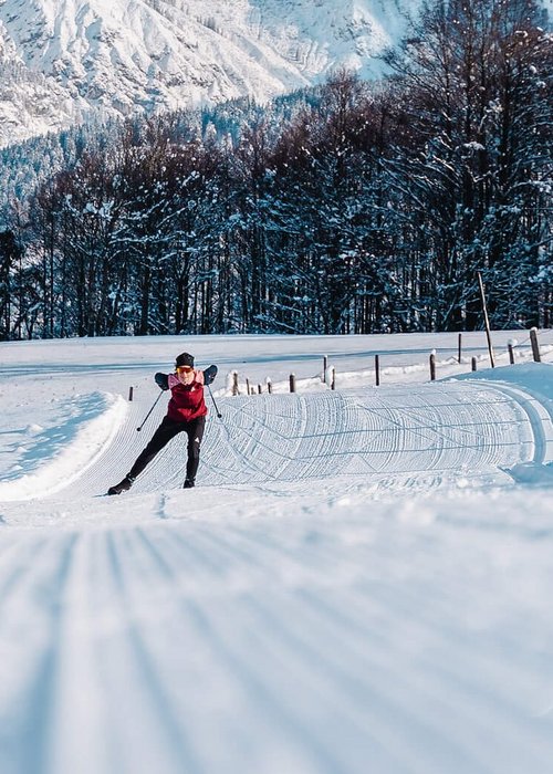 Langlauf Urlaub © Michael Geißler Langläufer auf verschneiter Loipe vor schneebedeckten Bergen