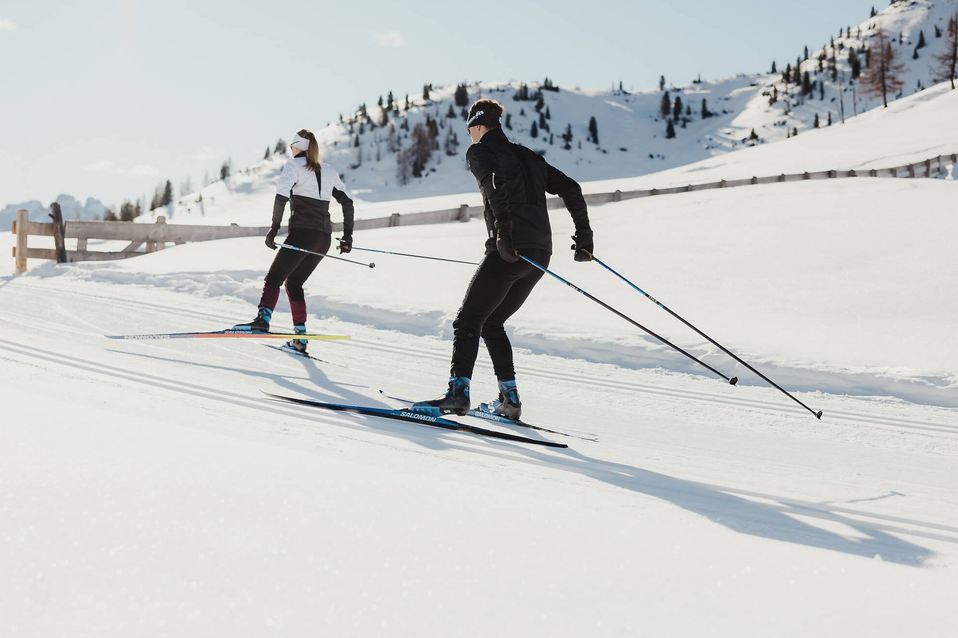 Langlauf Urlaub © Alex Moling Zwei Skifahrer beim Langlaufen auf verschneiten Bergen bei Sonnenschein