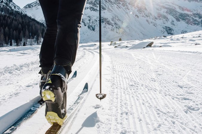 Langlauf Urlaub © Tourismusverein Passeiertal - Benjamin Pfitscher Person beim Langlaufen auf verschneiter Strecke mit Berglandschaft im Hintergrund