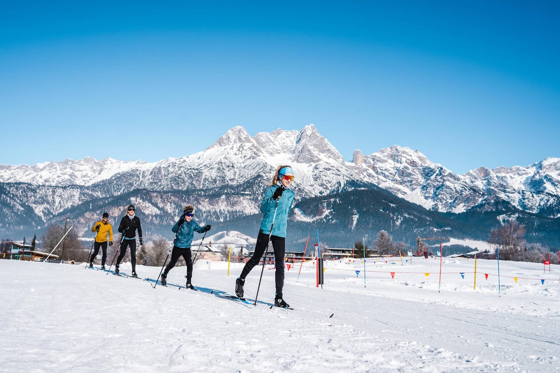 Cross Country Ski Holidays © Michael Geißler Group cross-country skiing in snowy landscape with mountains and clear blue sky