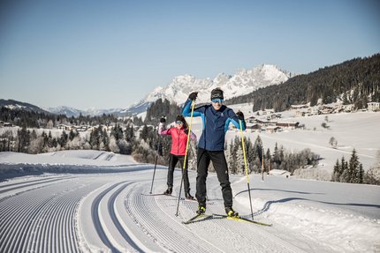 Volksbiathlon © Mirja Geh Zwei Menschen beim Langlaufen auf einer präparierten Loipe im schneebedeckten Gebirge