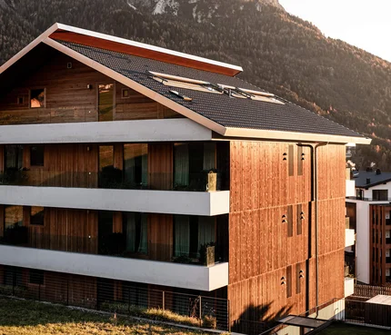 La Paula Apartments & Suites © Hannes Niederkofler Modern wooden house with snowy mountains in sunlight