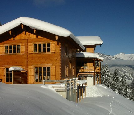 Bauerndörfl Rindereben © Bauerndörfl Rindereben Holzhaus im Schnee mit Bergen im Hintergrund