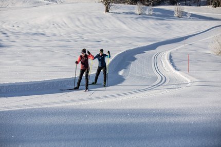 BMW IBU Weltcup © Mirja Geh Zwei Langläufer auf einer präparierten Schneeloipe bei sonnigem Wetter