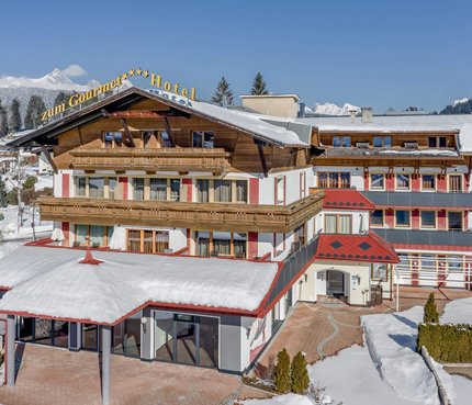 All Inclusive Hotel zum Gourmet © Archiv Marcati Schneebedecktes Hotelgebäude mit Bergen im Hintergrund