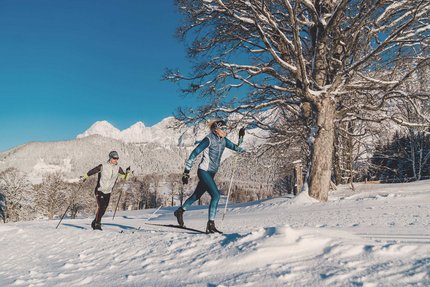 Dachsteinlauf 2026 © TVB Schladming Dachstein - Christine Höflehner Zwei Personen beim Langlaufen vor verschneiten Bergen und klarem Himmel