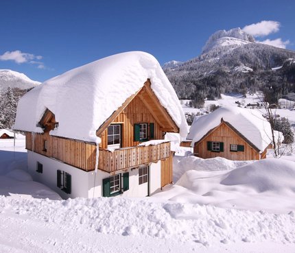 Hüttendorf – Aktiv & Naturresort AlpenParks Hagan Lodge © Gerhard Wolkersdorfer Holzhäuser mit dicken Schneeschichten im Winter in den Bergen