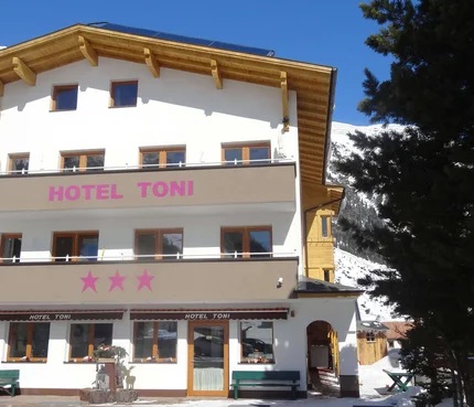Hotel Toni © Hotel Toni - Familie Walter KG Außenansicht von Hotel Toni mit Bergen und Schnee im Hintergrund