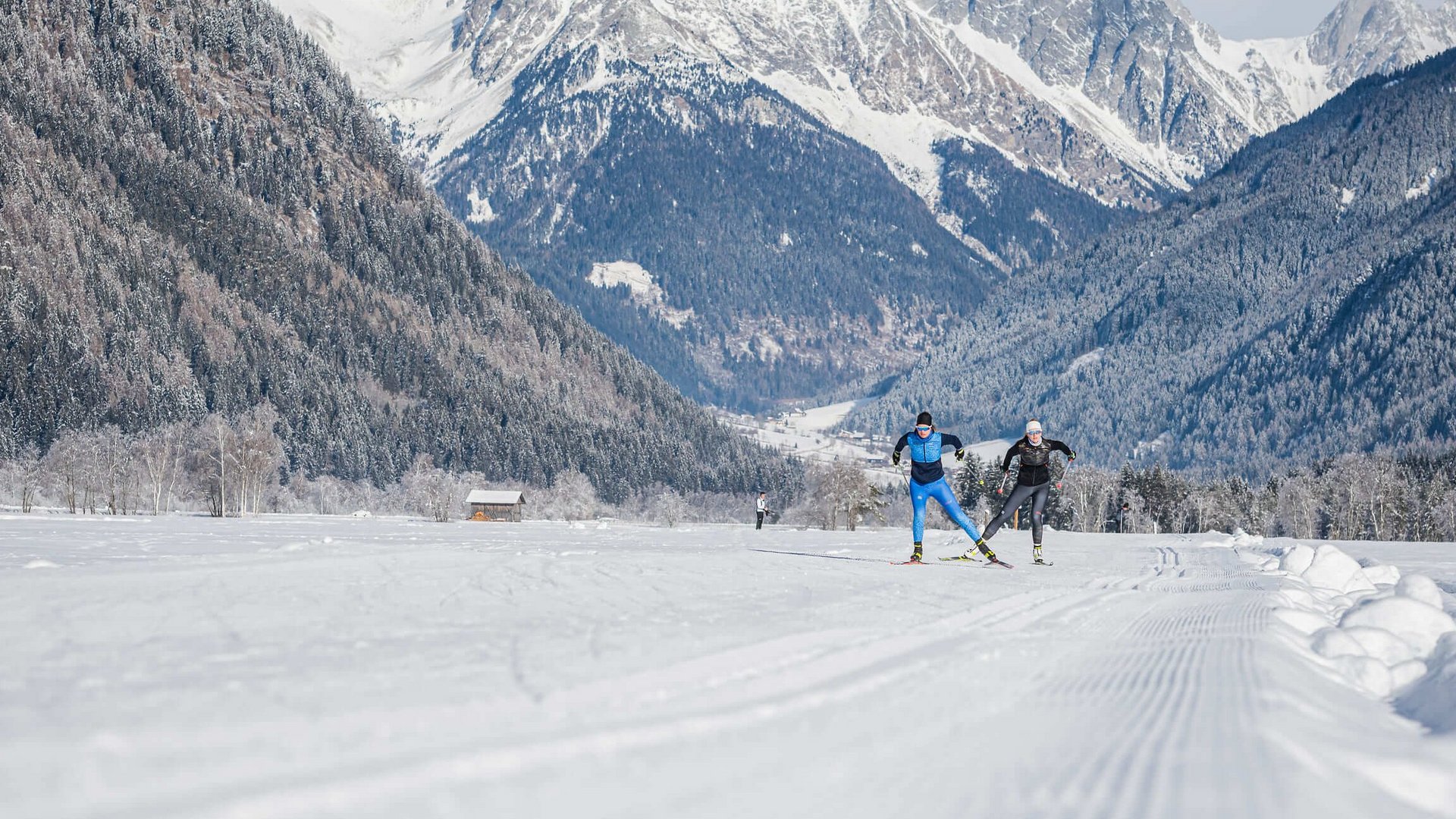 Langlauf Urlaub in der Dolomitenregion Kronplatz © Harald Wisthaler Skilangläufer auf verschneiter Strecke vor Bergkulisse in winterlicher Landschaft