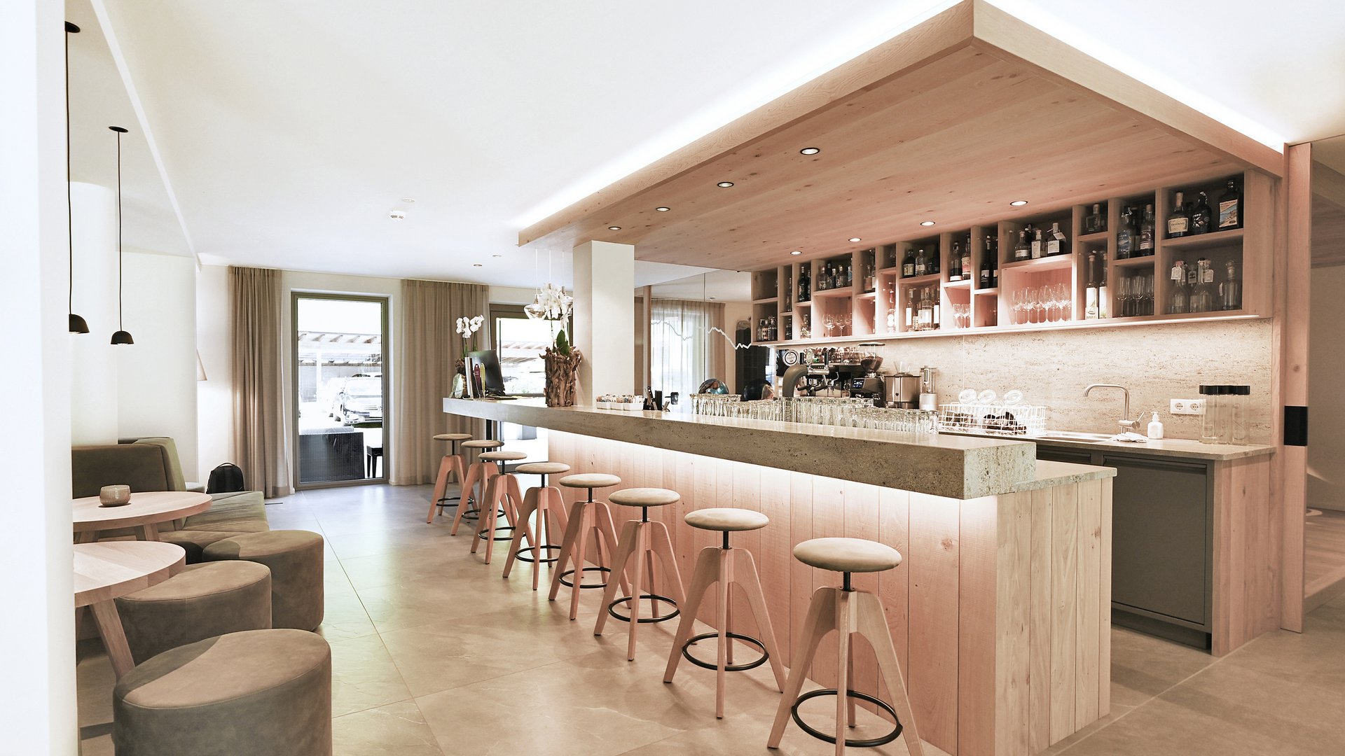 Hotel Vierbrunnenhof ***S © Justina Zdanoviciute Moderner heller Barbereich mit Holzstühlen und Sitzgelegenheiten