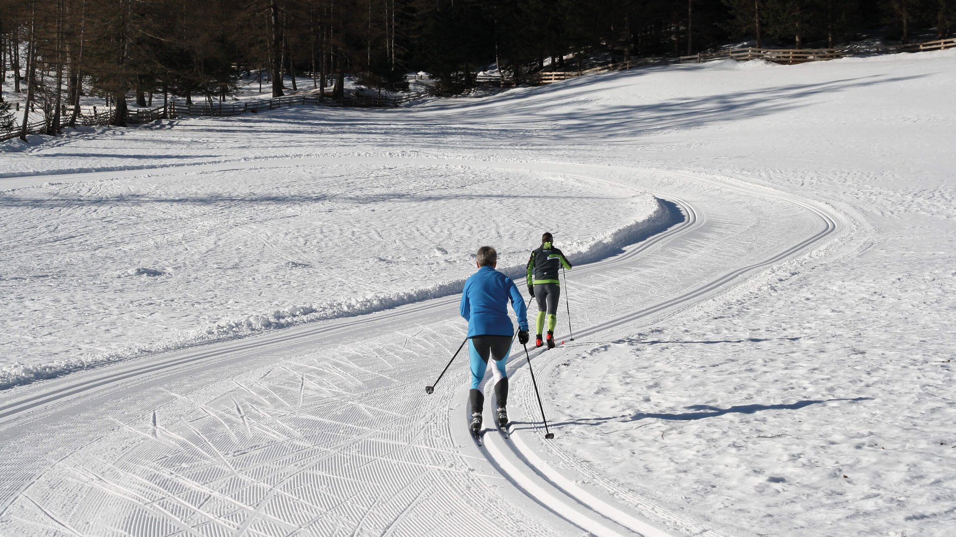Langlauf Urlaub im Sarntal © Judith Vasselai Zwei Langläufer auf verschneiter Loipe im Wald