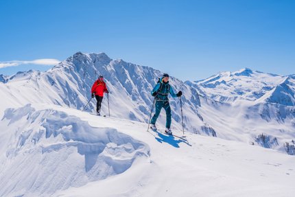Top 3 Must-Glide Skitouren im Großarltal © TVB Großarltal / Peter Maier Zwei Skitourengeher in bunten Outfits wandern im sonnigen, verschneiten Gebirge