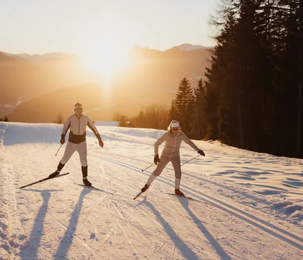 Seefeld Nordic Combined Triple © Alex Moling Zwei Langläufer im Sonnenuntergang auf verschneiter Strecke