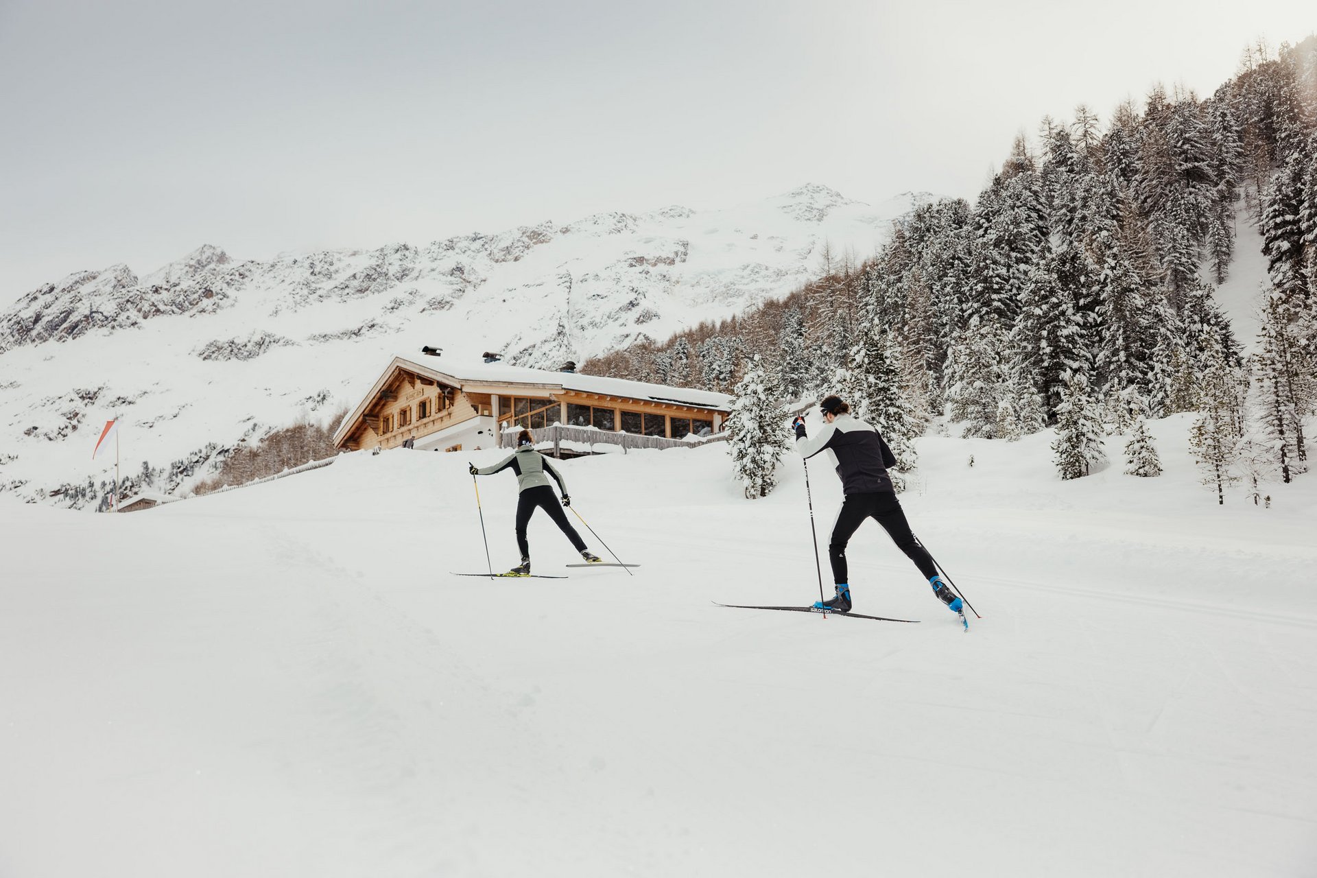 Langlauf Urlaub © Alex Moling Zwei Langläufer vor verschneiter Berghütte im Winter