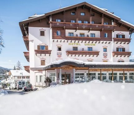 Hotel Union © Harald Wisthaler Hotel Union im Schnee mit Skifahrern und klarem Himmel