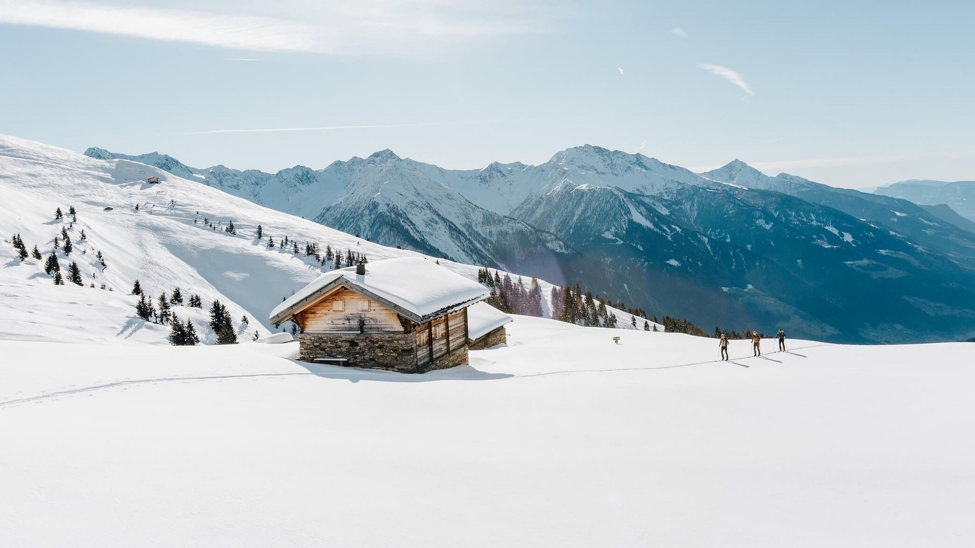 Skitouren Urlaub im Passeiertal © Tourismusverein Passeiertal - Benjamin Pfitscher Verschneites Berghaus mit Skiwanderern und sonnigem Himmel