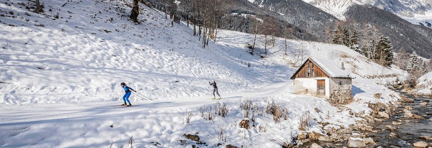 Hotel Vierbrunnenhof ***S © Harald Wisthaler Zwei Skilangläufer auf verschneiter Bergstrecke neben Bach und Hütte