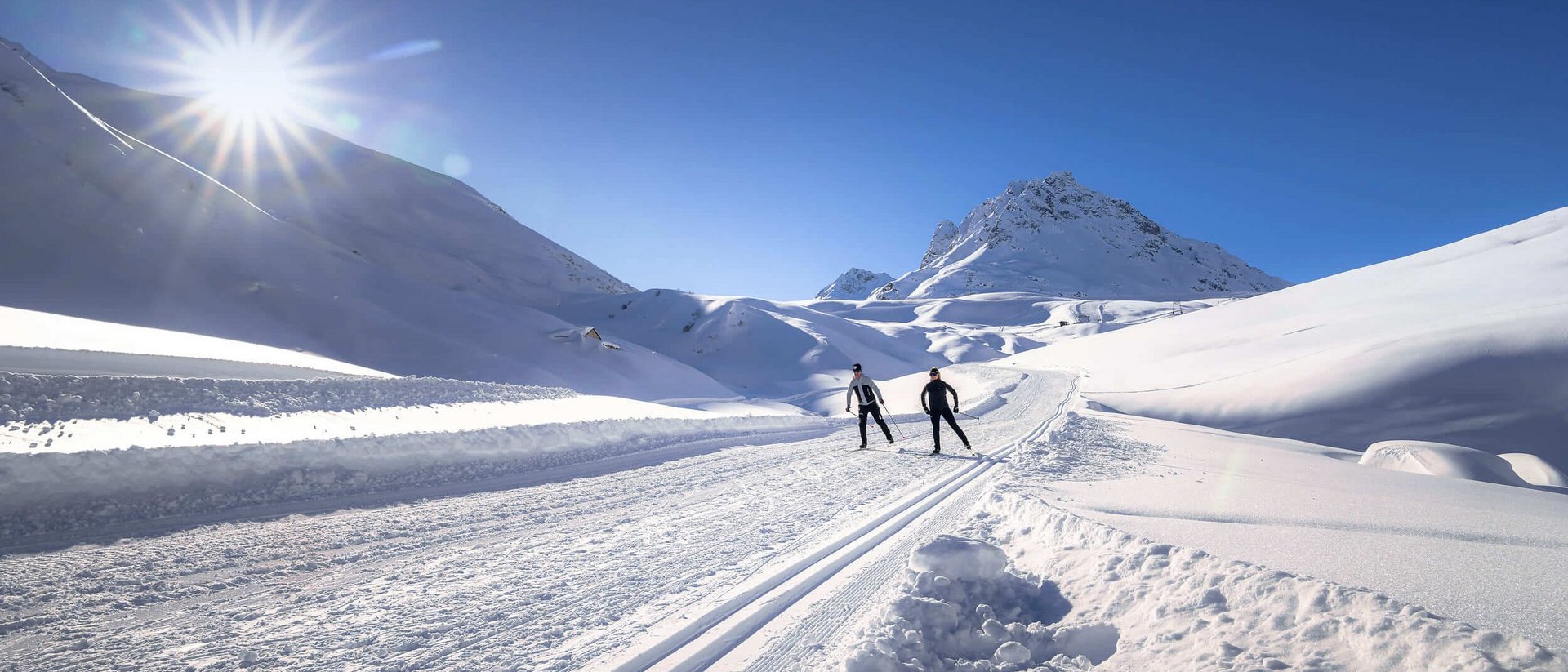 Osttirol © TVB Paznaun-Ischgl Zwei Skifahrer auf einer sonnigen, verschneiten Bergloipe