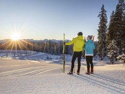 Filzmoos © Christian Fischbacher - Filzmoos Tourismus Two skiers enjoying the sunset in a snowy mountain landscape