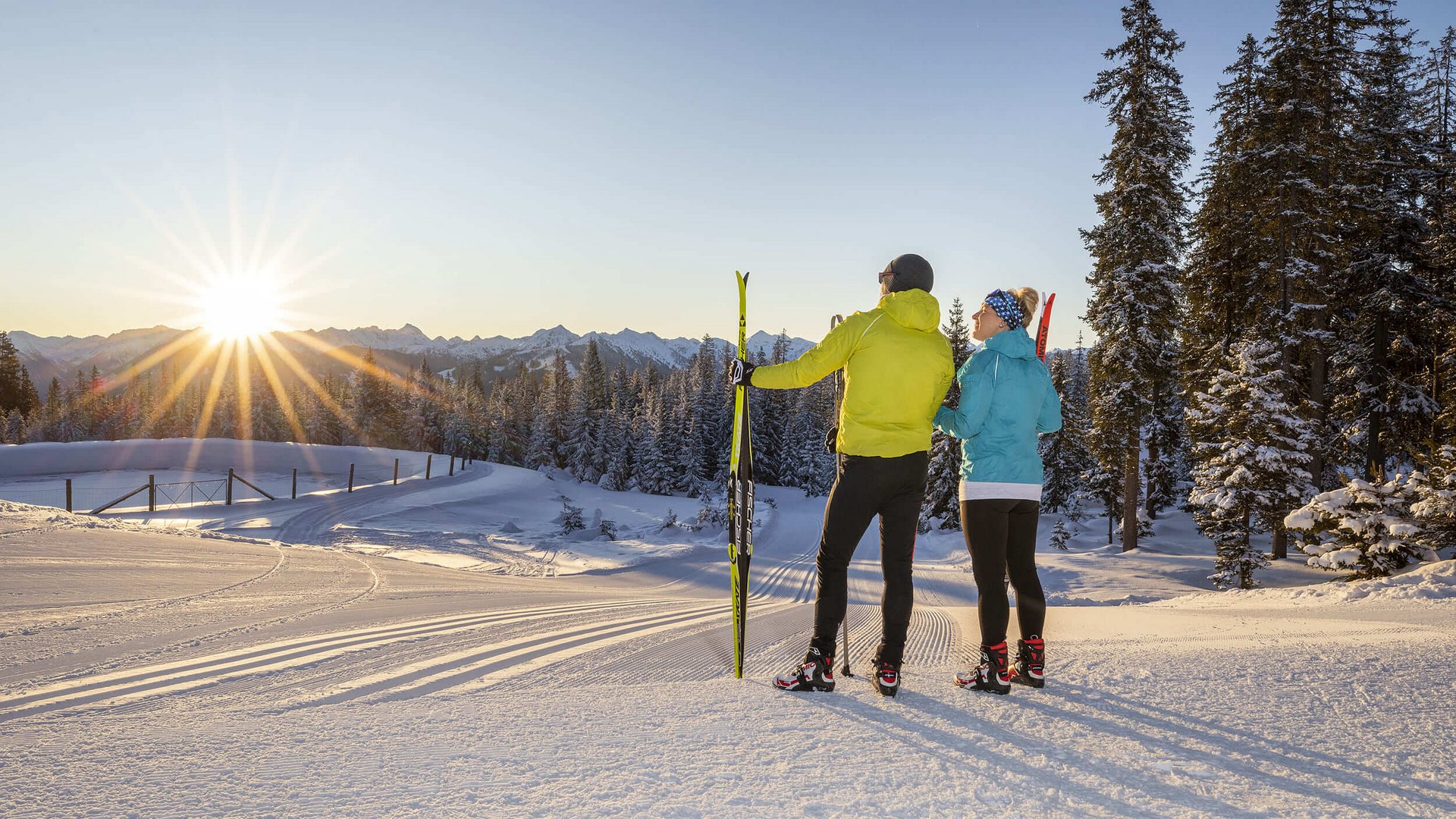 Langlauf Urlaub in Filzmoos © Christian Fischbacher - Filzmoos Tourismus Zwei Skifahrer genießen den Sonnenuntergang in verschneiter Berglandschaft