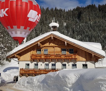 Bauernhof Krahlehen © Krahlehenhof - Fam. Haitzmann Heißluftballon über schneebedecktem Haus in winterlicher Landschaft