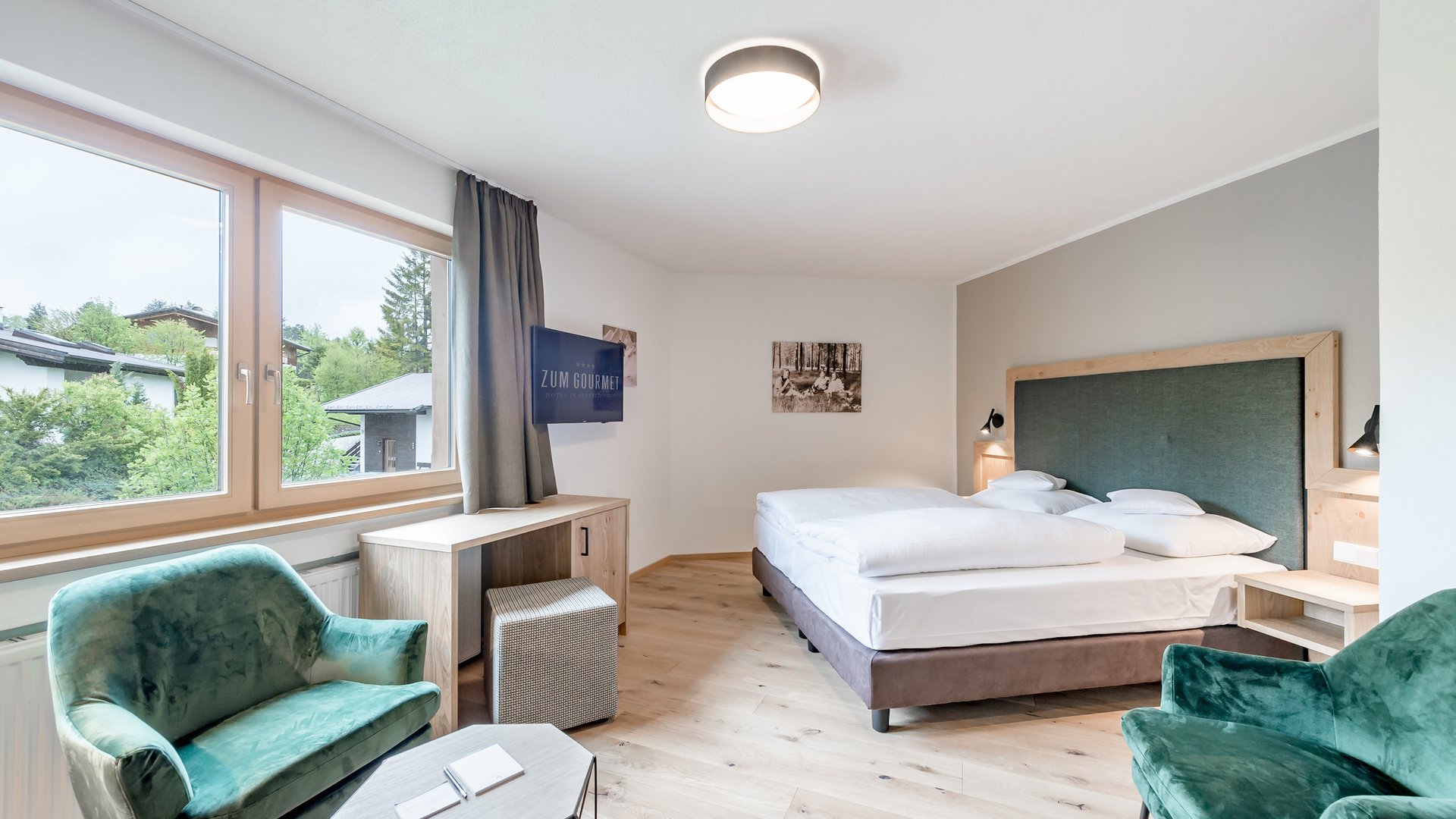 All Inclusive Hotel zum Gourmet **** © Archiv Marcati Hell eingerichtetes Hotelzimmer mit Doppelbett und grünen Sesseln