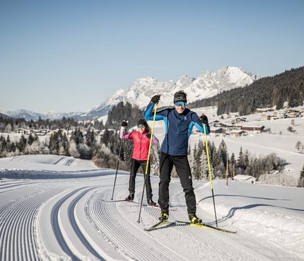 Volksbiathlon © Mirja Geh Zwei Menschen beim Langlaufen auf einer präparierten Loipe im schneebedeckten Gebirge