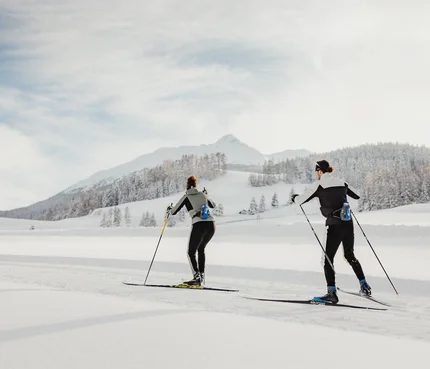 IBU Junior Cup 2025 © Alex Moling Zwei Personen beim Langlaufen in verschneiter Berglandschaft