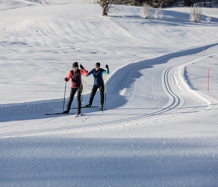 BMW IBU Weltcup © Mirja Geh Zwei Langläufer auf einer präparierten Schneeloipe bei sonnigem Wetter