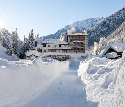 Hotel Waldheim © Alfred Tschager Schneebedeckter Weg zu einem Hotel im sonnigen Wintergebirge