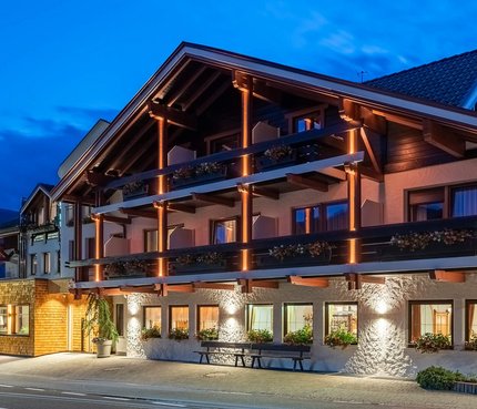 Hotel Brunnerhof © Hotel Brunnerhof der Brunner Christina & Co. KG Beleuchtetes alpines Hotelgebäude in der Abenddämmerung