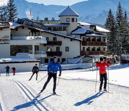 Alpenhotel Karwendel Relax & Spa © Hotel Karwendel Bernhard Rödlach BetriebsGmbH Langläufer vor dem Hotel Karwendel mit verschneiten Bergen im Hintergrund