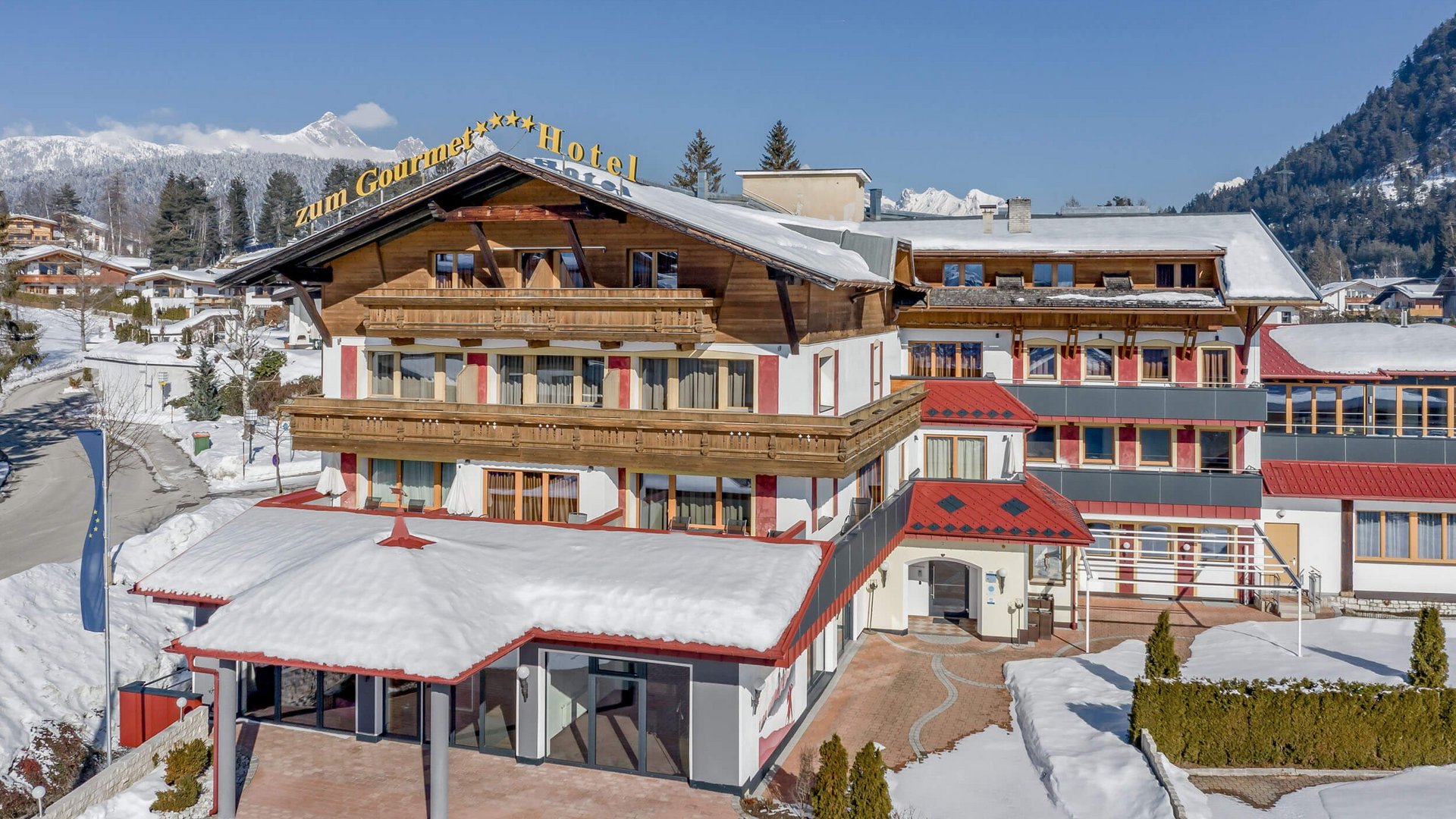 All Inclusive Hotel zum Gourmet **** © Archiv Marcati Schneebedecktes Hotelgebäude mit Bergen im Hintergrund