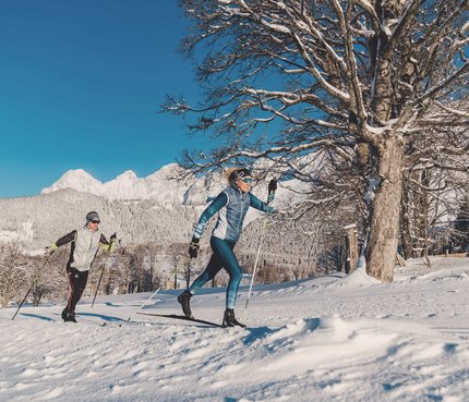 Dachsteinlauf 2026 © TVB Schladming Dachstein - Christine Höflehner Zwei Personen beim Langlaufen vor verschneiten Bergen und klarem Himmel