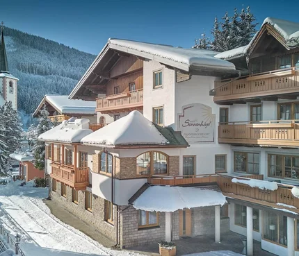 Hotel Sonnenhügel © Hotel Hanneshof GmbH Schnee bedeckte Berghütte neben einer Kirche im Winter