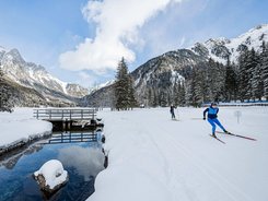 Dolomitenregion Kronplatz © Harald Wisthaler Langläufer unterwegs auf verschneiter Winterlandschaft mit Bergen und Wald